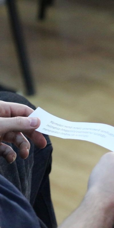 Bărbat ținând o hârtie cu text imprimat.