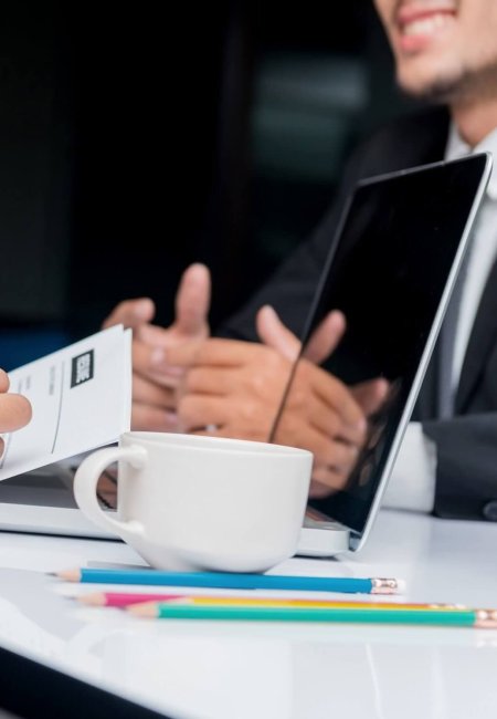 Întâlnire de afaceri la birou cu laptop și cafea.